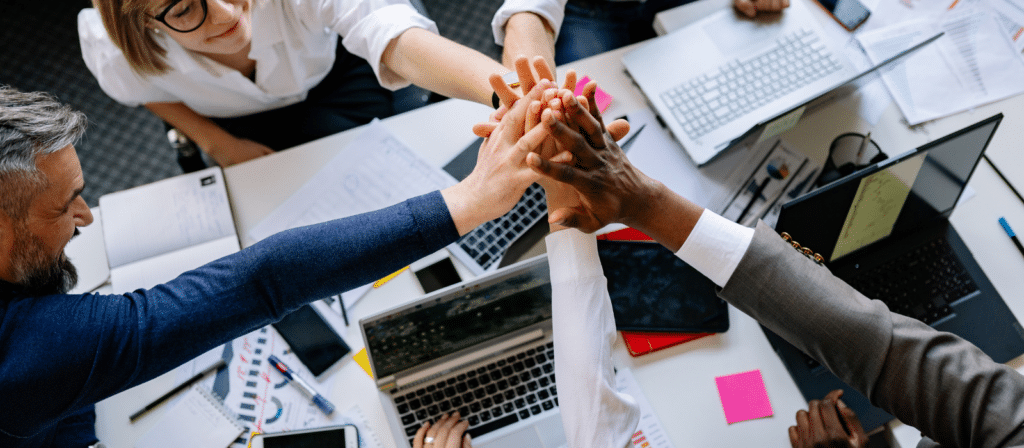 group of office hands high five